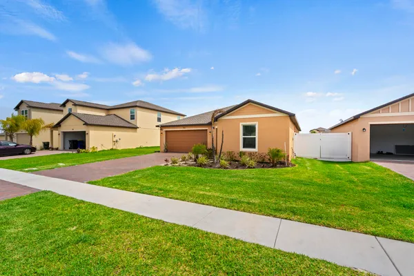 a view of a yard in front of a house with large trees