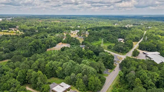 an aerial view of residential houses with outdoor space and trees