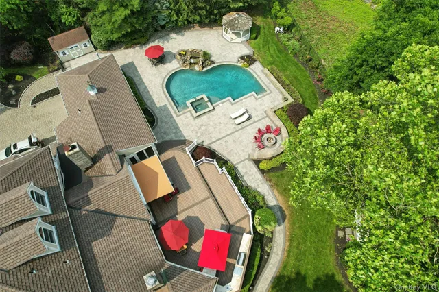an aerial view of a house swimming pool and red chairs