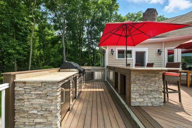 a view of a balcony with chairs and umbrella