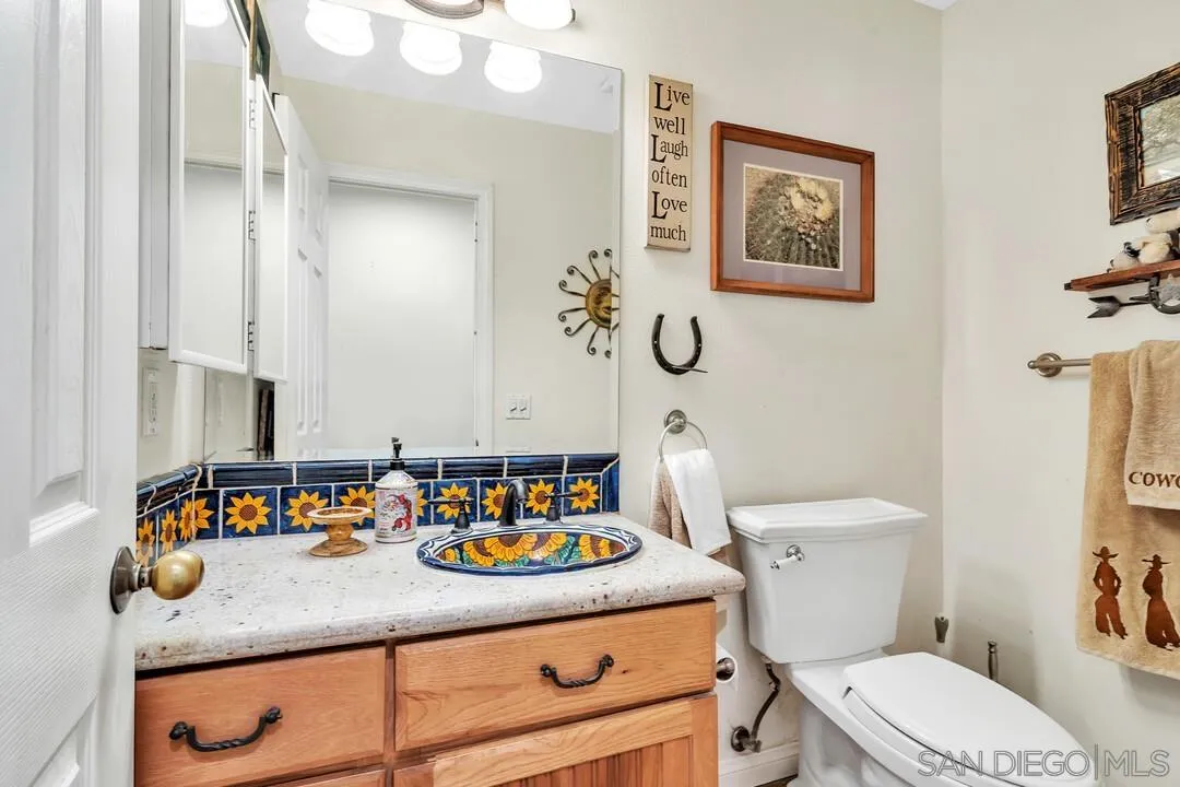 15127 Sycamore Canyon Road Poway, CA 92064 - Photo 25 of 47 a bathroom with a granite countertop sink mirror vanity and toilet