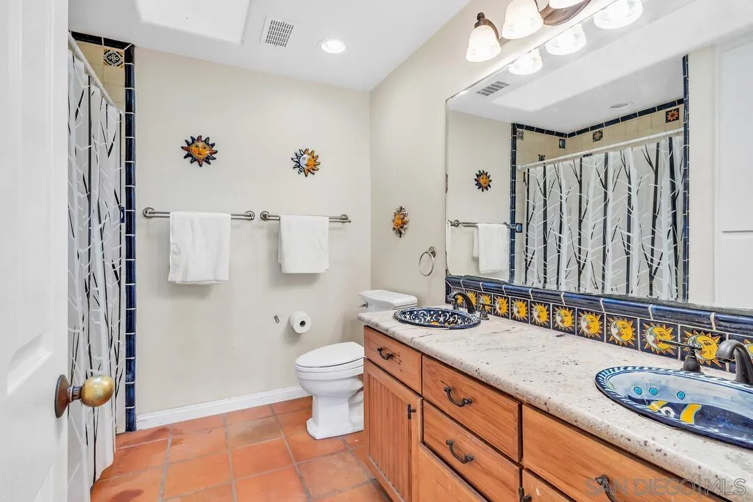 15127 Sycamore Canyon Road Poway, CA 92064 - Photo 26 of 47 a bathroom with a granite countertop sink a toilet and a shower