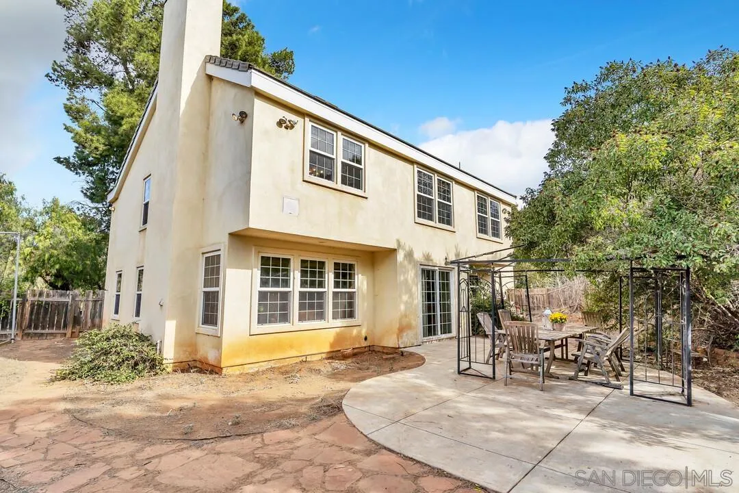 15127 Sycamore Canyon Road Poway, CA 92064 - Photo 38 of 47 a view of a white house with a chairs in patio