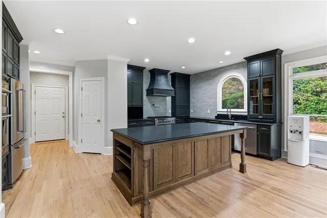 a kitchen with granite countertop a refrigerator and a stove top oven