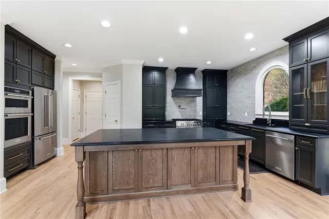 a view of an empty room with wooden floor a ceiling fan and windows