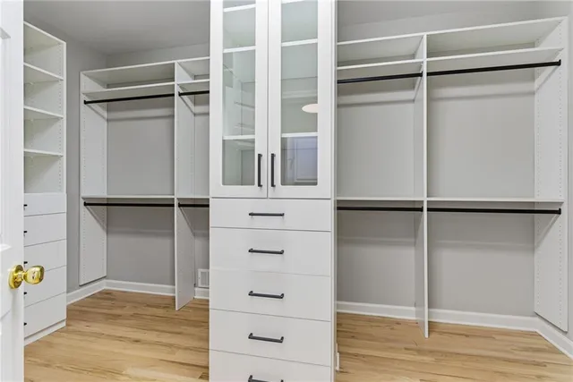 a view of a hallway with wooden floor and windows
