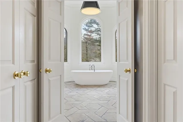 a view of an empty room with a chandelier fan