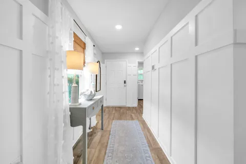 a view of a hallway with wooden floor and staircase