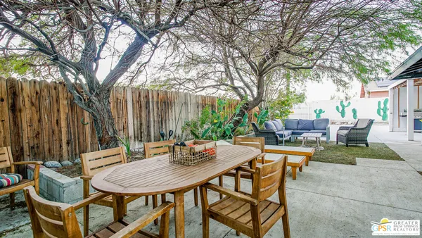 a backyard of a house with table and chairs