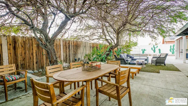 a backyard of a house with barbeque oven table and chairs