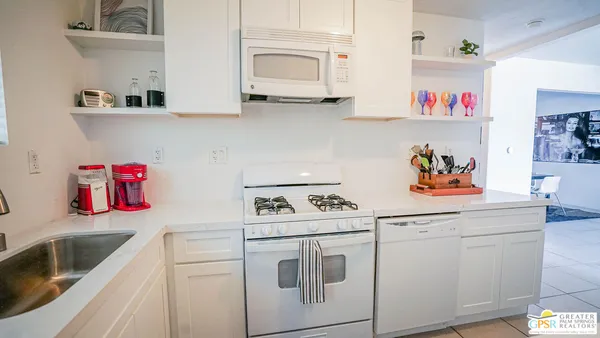 a kitchen with white cabinets and white appliances