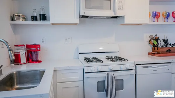 a kitchen with white cabinets and appliances