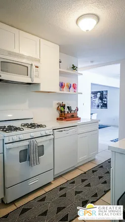 a kitchen with granite countertop a stove and cabinets