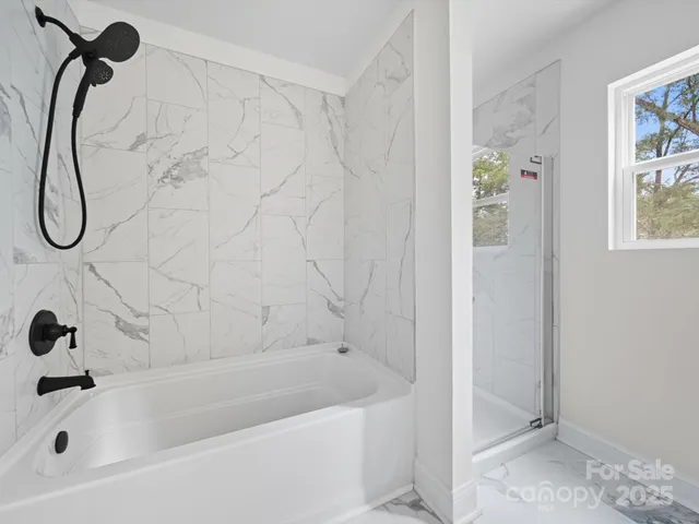 a bathroom with a bath tub with a shower