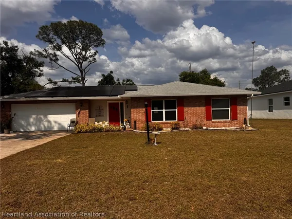 a view of a house with a yard and sitting area