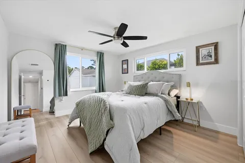a spacious bedroom with a bed and a chandelier