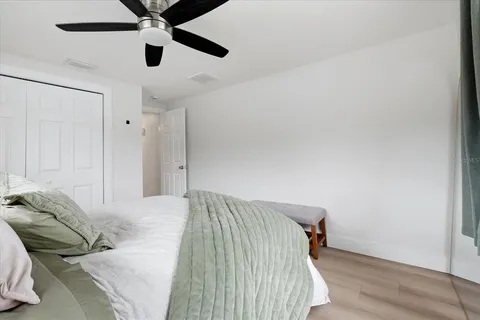 a bedroom with a bed and a ceiling fan