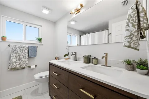 a bathroom with a sink a toilet and a mirror