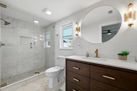a bathroom with a sink a toilet and shower
