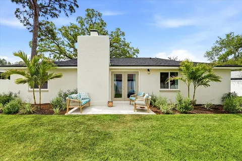 a view of a chair and table in backyard of the house