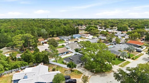an aerial view of residential houses with outdoor space and trees