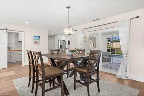 a view of a dining room and livingroom with furniture wooden floor a rug and a chandelier