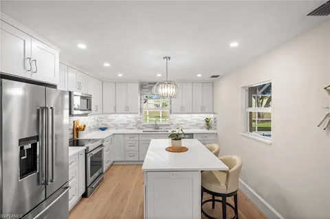 a kitchen with a refrigerator a stove and a dining table