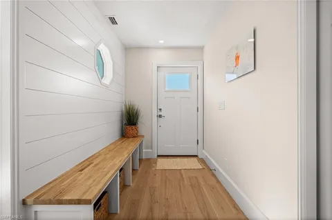 a view of a hallway with wooden floor and entryway