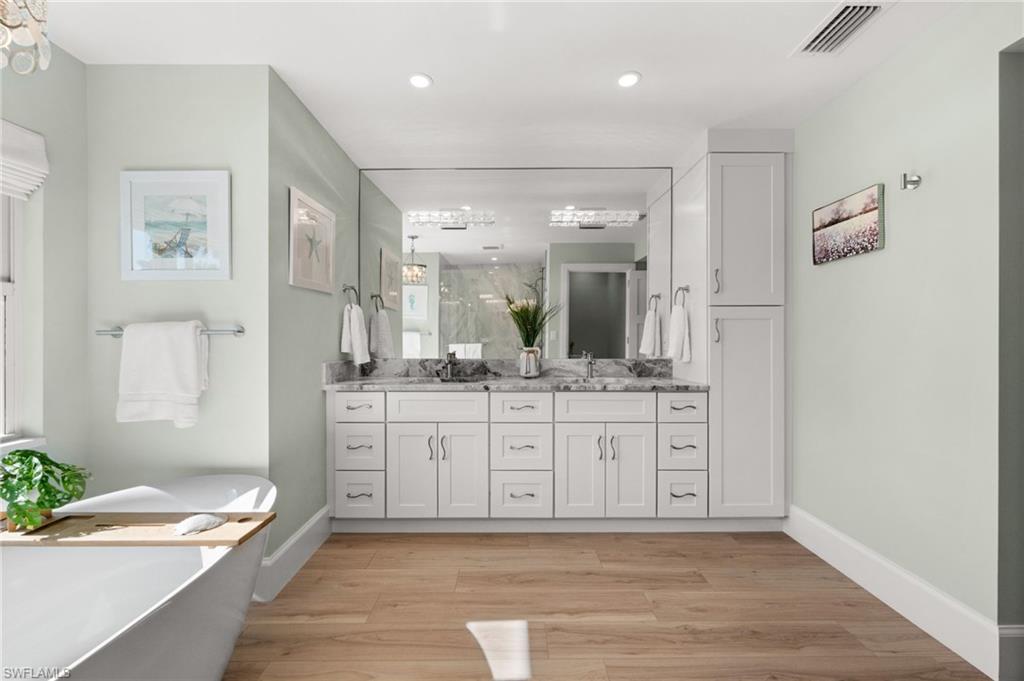 1925 Imperial Golf Course Boulevard Naples, FL 34110 - Photo 24 of 45 Beautifully designed for daily luxury , double sinks, generous storage, and a sleek mirrored wall create a serene setting for morning and evening routines.