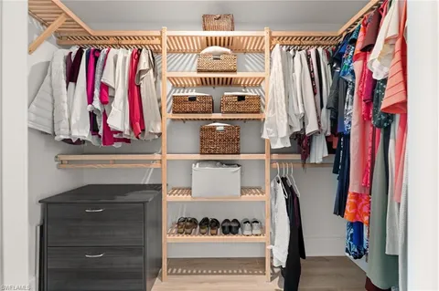 a view of walk in closet with clothes and shoes