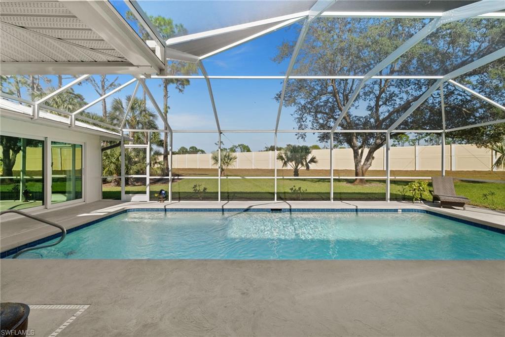 1925 Imperial Golf Course Boulevard Naples, FL 34110 - Photo 38 of 45 Resort-style living continues outdoors with a pristine pool framed by lush green space, offering both privacy and relaxation.