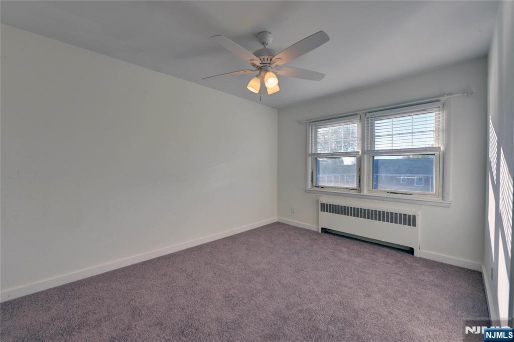 255 Bogert Road, Unit 2A River Edge, NJ 07661 - Photo 13 of 25 an empty room with chandelier fan and windows