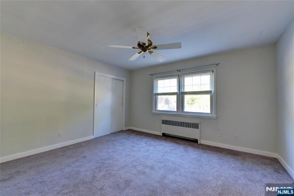 255 Bogert Road, Unit 2A River Edge, NJ 07661 - Photo 14 of 25 an empty room with chandelier fan and windows