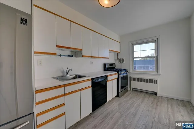 a kitchen with a sink a stove and cabinets