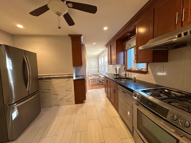 a kitchen with stainless steel appliances granite countertop a stove a refrigerator and a microwave