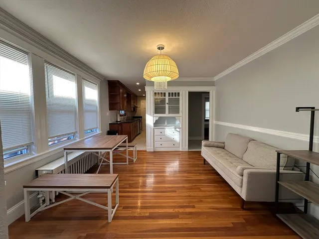 a spacious bedroom with a bed and a dresser with wooden floor