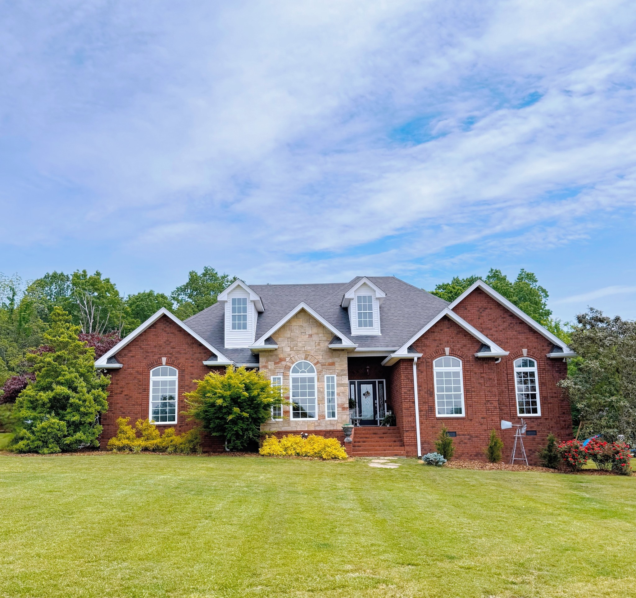 a front view of a house with yard and green space