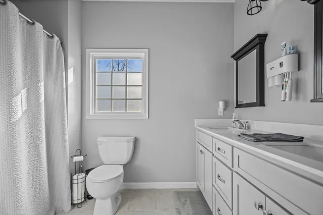 a bedroom with a bed and a flat tv screen on dresser