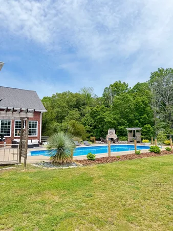 a swimming pool with outdoor seating and yard