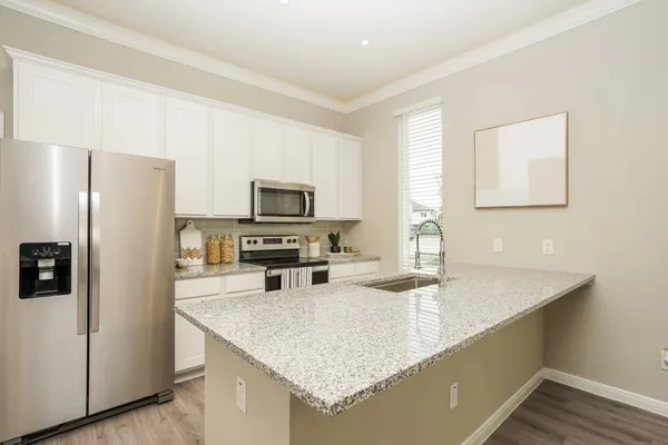 a kitchen with stainless steel appliances granite countertop a sink a stove and a refrigerator