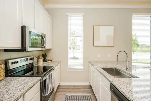 a kitchen with stainless steel appliances granite countertop a sink stove and cabinets