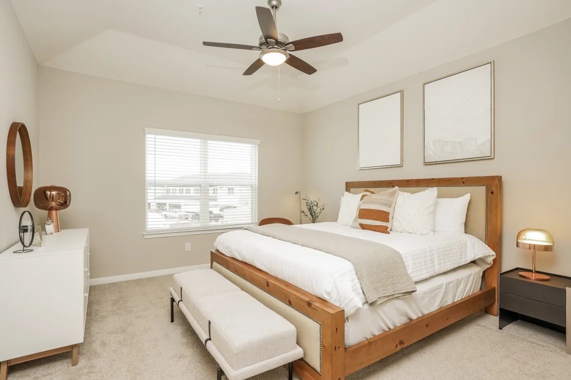 21455 Merchant's Way, Unit 103 Katy, TX 77449 - Photo 10 of 20 a bedroom with a bed a chandelier and a dresser