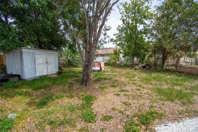 a front view of a house with a yard and large tree