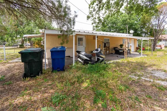 a backyard of a house with yard table and chairs