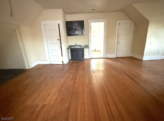 a view of a kitchen with wooden floor and a sink