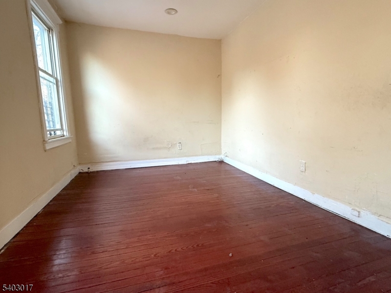 66 Scheerer Avenue Newark, NJ 07112 - Photo 20 of 24 an empty room with wooden floor and windows