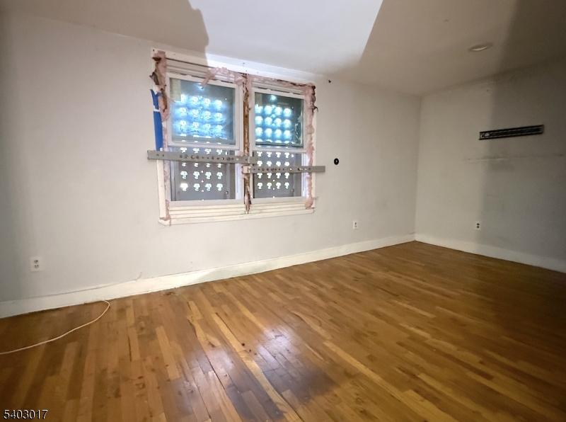 66 Scheerer Avenue Newark, NJ 07112 - Photo 22 of 24 a view of an empty room with wooden floor and a window