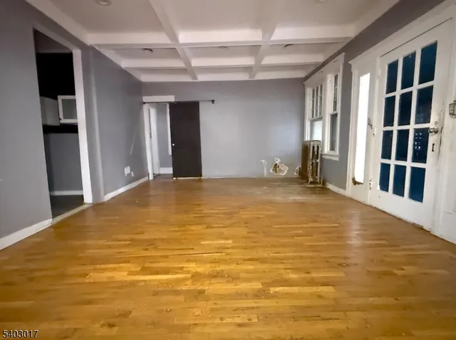 a view of an empty room with closet and windows
