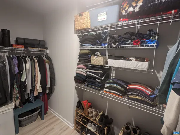 a view of walk in closet with clothes and shoes