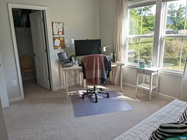 a view of a workspace with furniture and a window